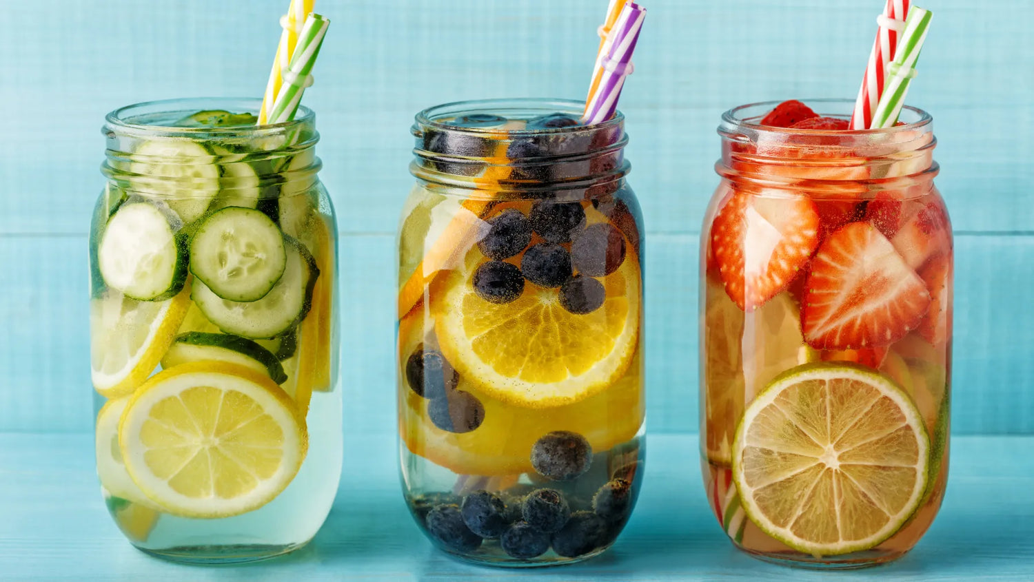 three mason jars filled with different fruits and water