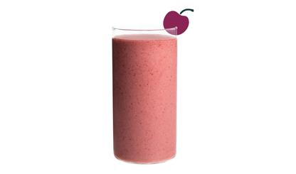 Blended Cherry Bomb smoothie in glass on white background - Frozen Garden cherry and mango smoothie.