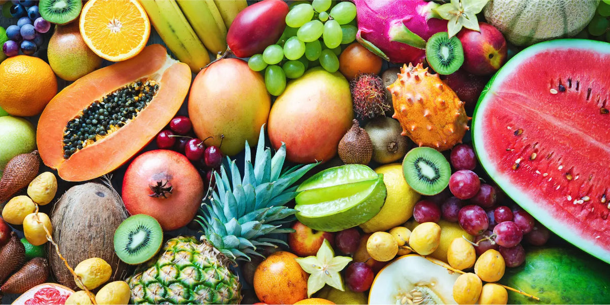Colorful overhead assortment of fresh tropical fruits including watermelon, mango, dragon fruit, and kiwi