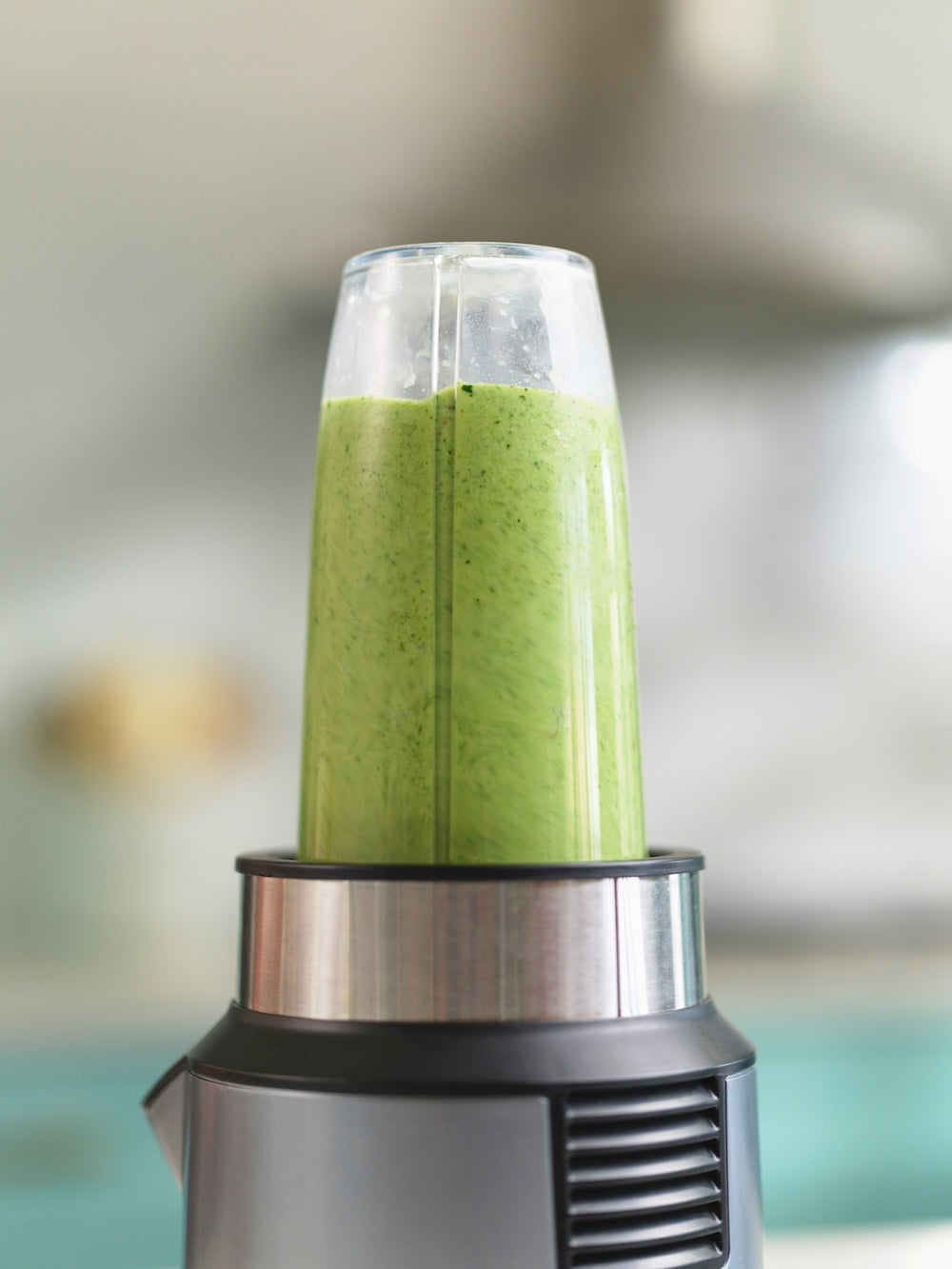 Blender with a blended green smoothie from Frozen Garden's smoothie delivery service.