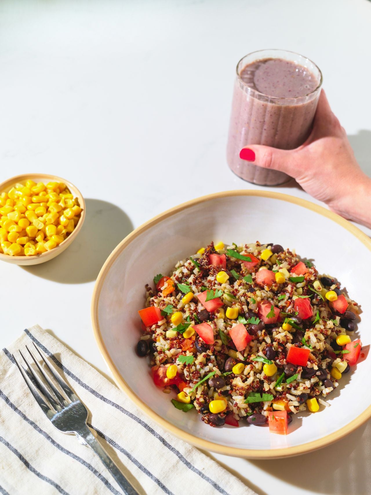 Tabletop view of Frozen Garden's Fiesta Garden Bowl ready to eat with a delicious blended smoothie