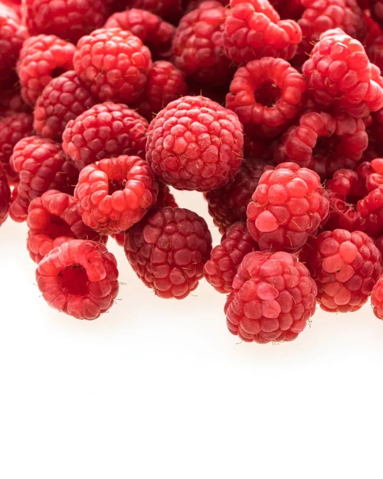 A pile of fresh red raspberries, a high-water content fruit used in Frozen Garden smoothies for natural hydration and fiber