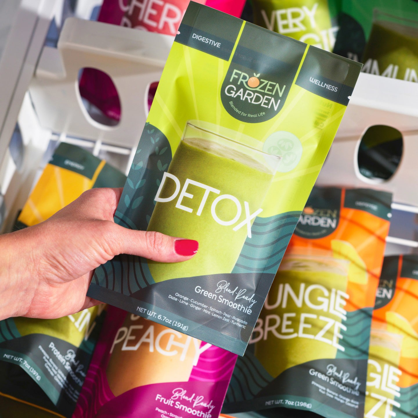 Woman's hand pulling a Frozen Garden frozen smoothie pack out of the freezer