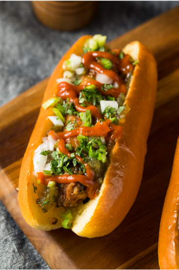 Plant-based sausage with various toppings on a wooden board