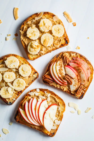 Four slices of toast with different toppings on a light gray background