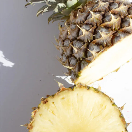 Close-up of a fresh pineapple cut open to reveal juicy yellow flesh, illustrating water-rich fruits that help with hydration.